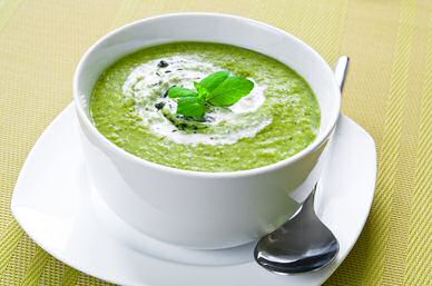 Gepureerde broccolisoep met een dot boursin, crème fraîche en een blaadje basilicum